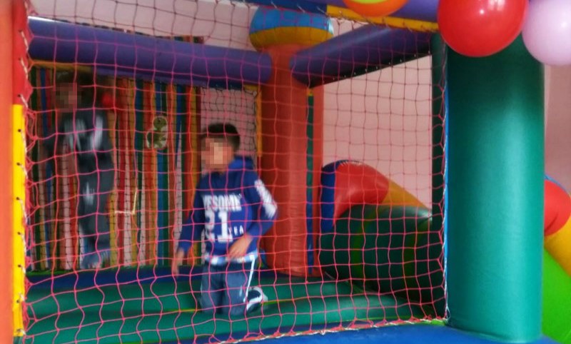 Foto de niño jugando en castillo inflable