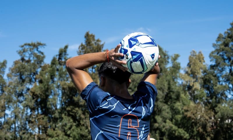 Joven con la pelota en la mano sacando un lateral