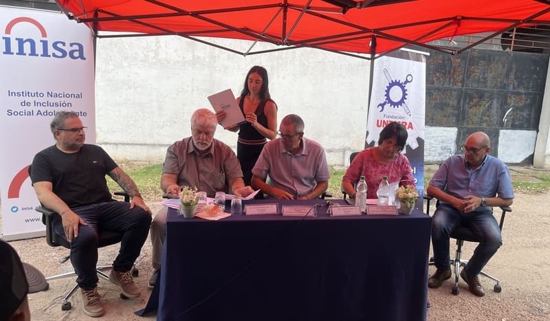 Autoridades sentadas firmando convenio