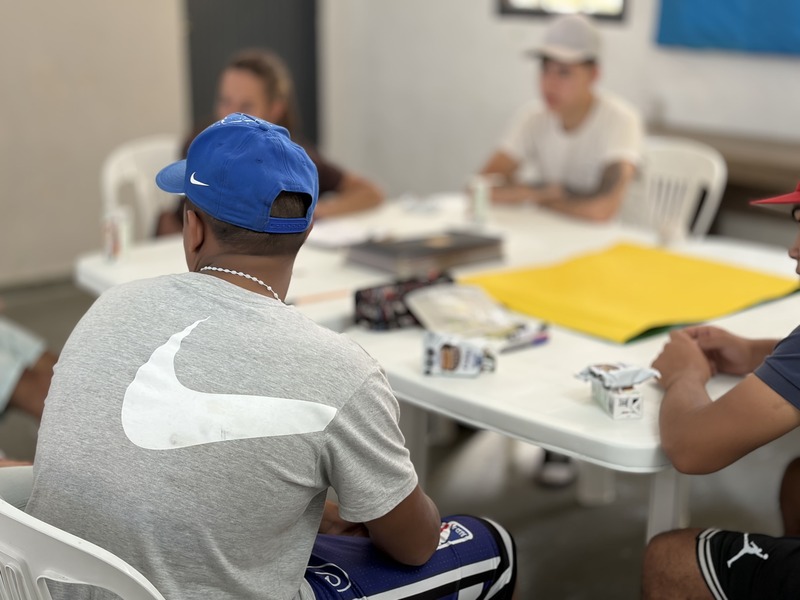Joven de espalda sentado frente a un escritorio